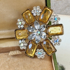 Vintage gold‑tone floral brooch with yellow emerald‑cut rhinestones and clear AB rhinestone clusters.