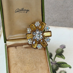 Vintage gold‑tone floral brooch with yellow emerald‑cut rhinestones and clear AB rhinestone clusters.