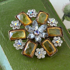 Vintage gold‑tone floral brooch with yellow emerald‑cut rhinestones and clear AB rhinestone clusters.