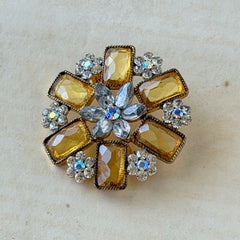 Vintage gold‑tone floral brooch with yellow emerald‑cut rhinestones and clear AB rhinestone clusters.