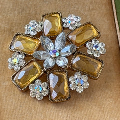 Vintage gold‑tone floral brooch with yellow emerald‑cut rhinestones and clear AB rhinestone clusters.