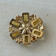 Vintage gold‑tone floral brooch with yellow emerald‑cut rhinestones and clear AB rhinestone clusters.