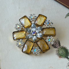 Vintage gold‑tone floral brooch with yellow emerald‑cut rhinestones and clear AB rhinestone clusters.