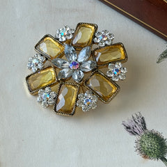 Vintage gold‑tone floral brooch with yellow emerald‑cut rhinestones and clear AB rhinestone clusters.
