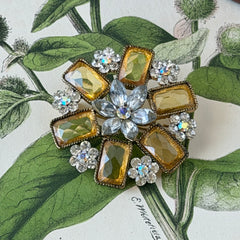 Vintage gold‑tone floral brooch with yellow emerald‑cut rhinestones and clear AB rhinestone clusters.
