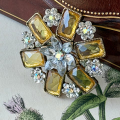 Vintage gold‑tone floral brooch with yellow emerald‑cut rhinestones and clear AB rhinestone clusters.