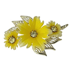 Vintage yellow celluloid floral brooch from the 1950s featuring three gradient yellow-to-white flowers with clear rhinestone centers, accented by light gold-tone openwork leaves.