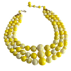 Vintage 1950s yellow three‑strand necklace with graduated cellulose acetate beads in solid and marbled tones, shown in various views to display bead details and overall design.