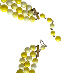 Vintage 1950s yellow three‑strand necklace with graduated cellulose acetate beads in solid and marbled tones, shown in various views to display bead details and overall design.